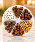 Celebration of Del's gourmet snack tray with six compartments of chocolate treats, roasted nuts, fudge, and frosted pretzels.