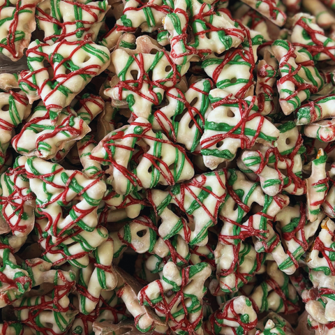 Close-up of Christmas tree-pretzels cookies with red and green icing.