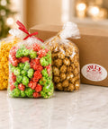 Del's Little Helper gift box with three bags of gourmet popcorn in assorted flavors displayed beside a Del's branded gift box.