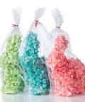 Three bags of colorful popcorn easter bunnies, one green, one blue, and one pink, packed with pink ribbons.
