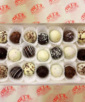 Box of assorted chocolate truffles on a Del's branded background