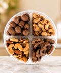 Taste of Del's with assorted nuts and pretzels in a compartmentalized container on a blurred background