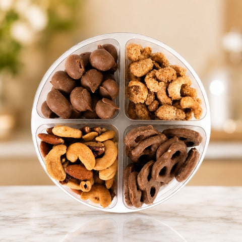Taste of Del's with assorted nuts and pretzels in a compartmentalized container on a blurred background