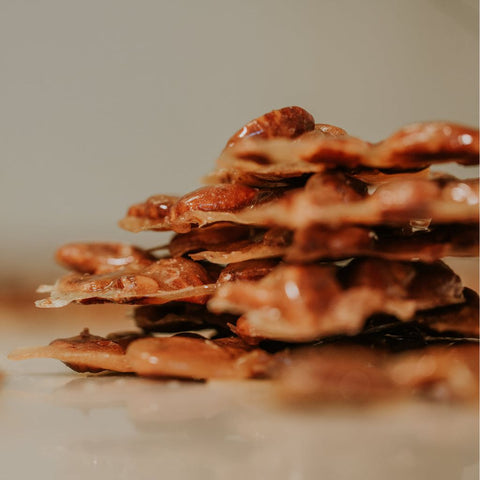 Stack of ultra thin, crispy peanut brittle with a blurred background